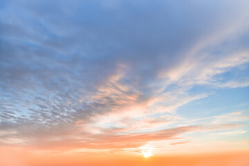 A beautiful sky tinted by the sun leaving vibrant shades of gold, pink, blue and multicolored. Clouds in the twilight evening and morning sky. Cloudy sky background in the evening and during the day.