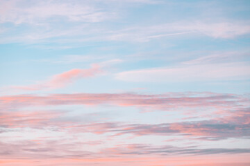 A beautiful sky tinted by the sun leaving vibrant shades of gold, pink, blue and multicolored. Clouds in the twilight evening and morning sky. Cloudy sky background in the evening and during the day.