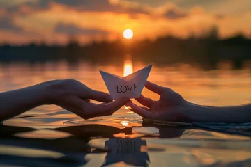 Tableaux ronds sur aluminium Coucher de soleil sur la plage An intimate shot of a couple's hands releasing a paper boat into a serene lake, with "LOVE" written in elegant calligraphy on the sail, against a backdrop of golden sunset reflections on the water