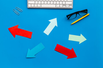 Paper arrows on office desk - business problem solving options