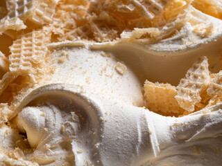 Frozen Creamy flavour gelato (called Russian Ice Cream) - full frame detail. Close up of a white surface texture of Ice cream covered with pieces of broken waffle.