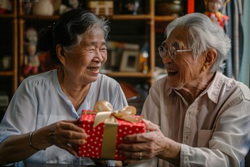 An elderly asian couple exchanging heartfelt gifts on their anniversary, their faces alight with happiness and love as they express their appreciation for each other's enduring presence in their lives