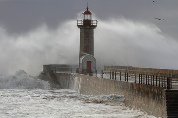 Stormy wave splash and spray at old lighthouse