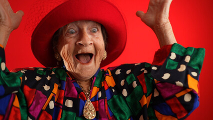 Funny fisheye of elderly senior old woman with wrinkled skin wearing red hat gives great idea...