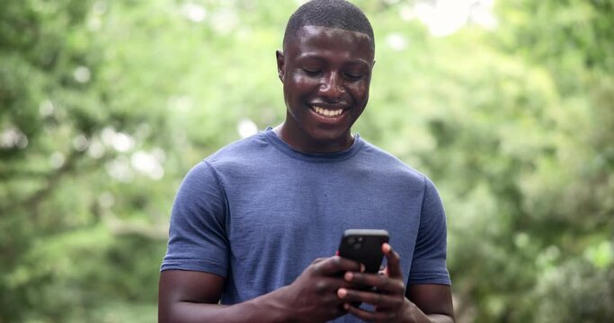Fitness, phone and black man laughing in a park for social media, chat or location search in nature. Smartphone, app and runner in a forest with online comic, joke or meme, text and gif communication
