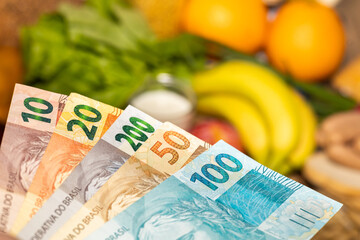 Food prices in Brazil, Economic concept, File of Brazilian money reais against the background of different types of food products, Cost of living in Brazil