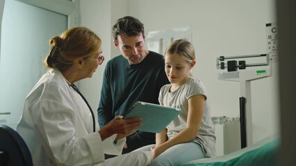 In a clinic or hospital, a doctor does a health check up on a little girl accompanied by her father.
Medicine and prevention concept - Powered by Adobe