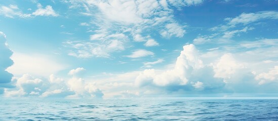 Vibrant Blue Sky with Puffy Clouds Blanketing the Serene Ocean Horizon