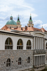Fototapeta na wymiar Ljubljana, Slovenia; The Ljubljana Dragon Bridge spans the Ljubljanica River, Ljubljana Central Market and Saint Nicholas's Cathedral (Katedrala Sv. Nikolaj), dragon sculpture