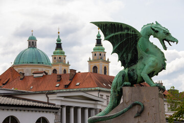 Obraz premium Ljubljana, Slovenia; The Ljubljana Dragon Bridge spans the Ljubljanica River, Ljubljana Central Market and Saint Nicholas's Cathedral (Katedrala Sv. Nikolaj), dragon sculpture