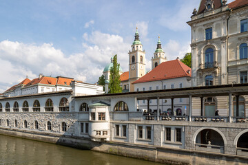Fototapeta premium Mesarski most, butcher's bridge, bridge with padlocks spans the promenade Ljubljanica River, with viewa to Ljubljana Central Market and Saint Nicholas's Cathedral and Ljubljana Castle, Slovenia