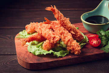 Fried shrimp, peeled in tempura, soy sauce, close-up, on a wooden board,