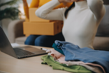 Asian SME business women use laptop computer checking customer order online shipping boxes at home....