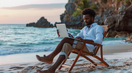 man sitting on a beach chair using a laptop by the sea