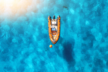 Aerial view of beautiful orange boat in blue sea at sunset in summer. Sardinia, Italy. Top drone view of motorboat, ocean with transparent azure water. Travel. Tropical landscape. Yachting. Seascape - 758213272