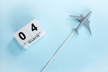 March calendar with number  4. Top view of a calendar with a flying passenger plane. Scheduler....