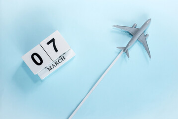 March calendar with number  7. Top view of a calendar with a flying passenger plane. Scheduler....
