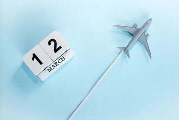 March calendar with number  12. Top view of a calendar with a flying passenger plane. Scheduler....