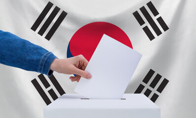 Elections, South Korea. The concept of elections. A hand throws a ballot into the ballot box. The...
