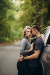 happy couple near the car in the forest