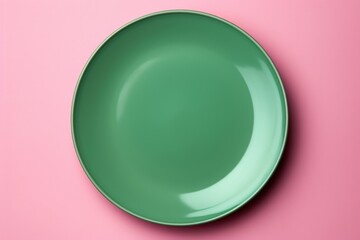 A simple green plate on a vibrant pink background. Perfect for food or kitchen related projects