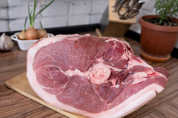 Real men cutting fresh raw meat on  board in white kitchen. Preparing pork meat, cooking