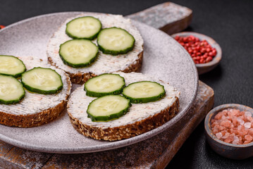 Delicious vegetarian sandwich with grilled toast, cream cheese, cucumbers and seeds