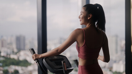 Fit woman exercising on elliptical trainer