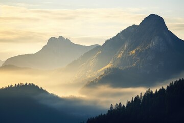 A serene view of a mountain range with a foggy valley below. Ideal for nature and landscape themed...