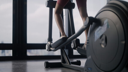 Fit woman exercising on elliptical trainer