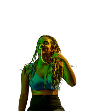 Mujer joven morena afroamericana con trenzas largas y ropa deportiva, fotos en movimiento, iluminada con luces de colores amarillas y verdes