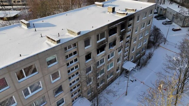 Drone footage of a few burned up apartments in in multistory houses and iced up windows during winter day