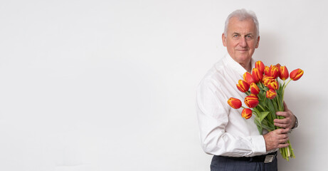 Handsome old man with a bouquet of tulips.