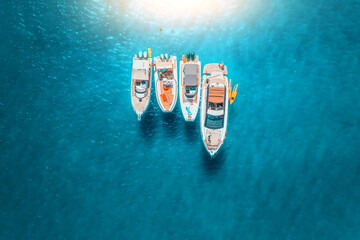 Aerial view of luxury yachts and boats on blue sea at sunset in summer. Travel in Sardinia, Italy. Drone view from above of speed boats, yachts, sea lagoon, transparent azure water. Seaside - 758230828