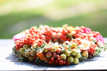 Handmade colorful floral autumn wreath made of wild fruits,  leaves and flowers. Natural floral...