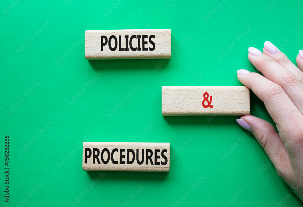 Poster Policies and Procedures symbol. Concept words Policies and Procedures on wooden blocks. Beautiful green background. Businessman hand. Business and Policies and Procedures concept. Copy space.