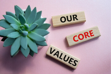 Our core values symbol. Concept words Our core values on wooden blocks. Beautiful pink background...