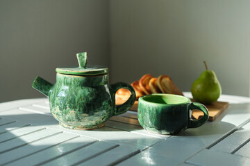 Delicious breakfast, snack pancakes, green tea, fresh pear, green teapot, tea on a gray background,...