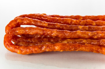 Many thin sausages on a white background