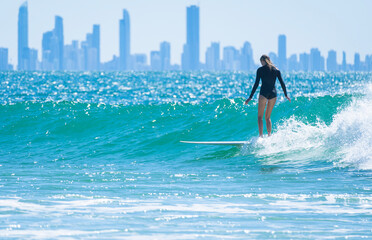 Young woman learning to surf on the beach in Gold Coast town, Queensland, Australia