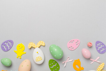 Easter eggs and cute decoration on color background, top view