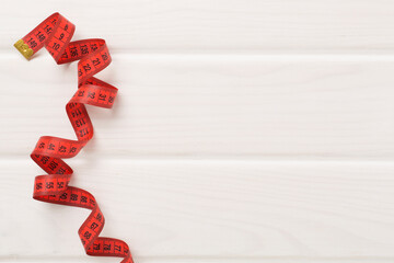 Measuring tape on wooden background, top, view