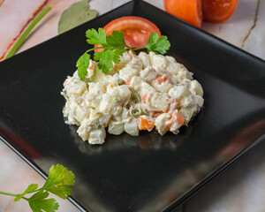 Russian salad Creamy potato salad garnished with parsley on a black plate, typical food, typical mediterranean mallorcan cuisine typical from balearic islands mallorca, spain