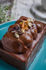 Photograph a piece of chocolate cake with walnuts on top
