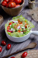 photography of healthy food, a bowl of fresh salad with lettuce, radishes, tomatoes among others

