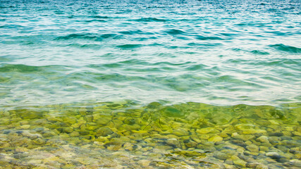 Stones in the sea near the shore under clear water