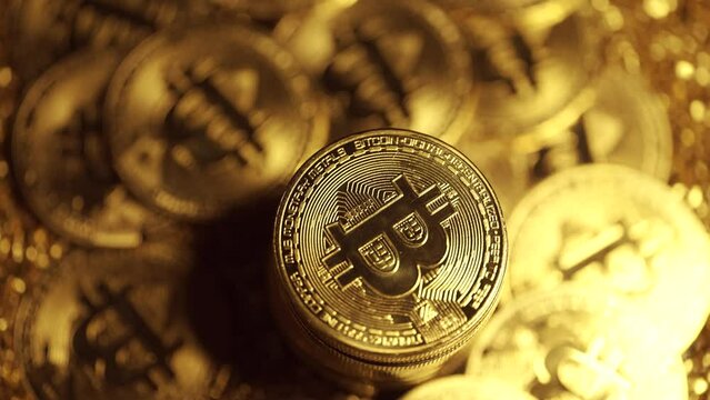 Golden bitcoin coins are rotating on a dark background. Virtual cryptocurrency payment system and digital gold concept. BTC coin mining. Spinning bitcoins.