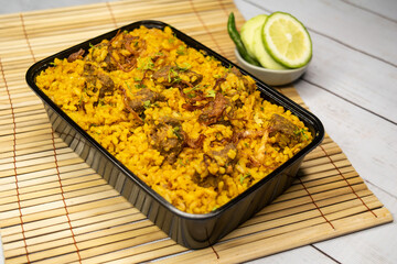 beef khichuri biryani rice pulao with cucumber and lemon slice served in dish isolated on wooden table side view of bangladeshi and indian spicy food