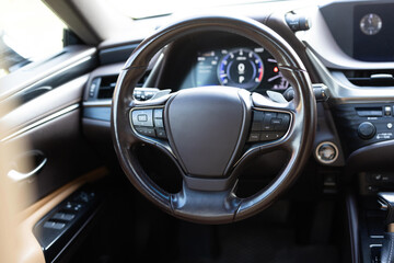 Car steering wheel. Brown leather dashboard, climate control, speedometer, display, wood...