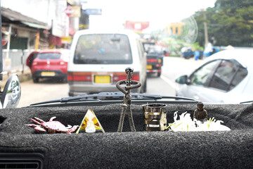 A few statues of lord buddha and some toys on a car dashboard, Kandy, Sri Lanka.